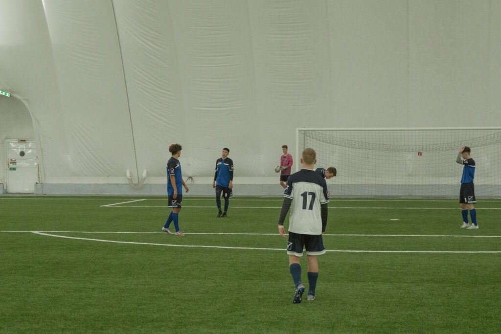 pexels-photo-6077789-6077789-1 Indoor soccer game with players focusing on strategy and movement.